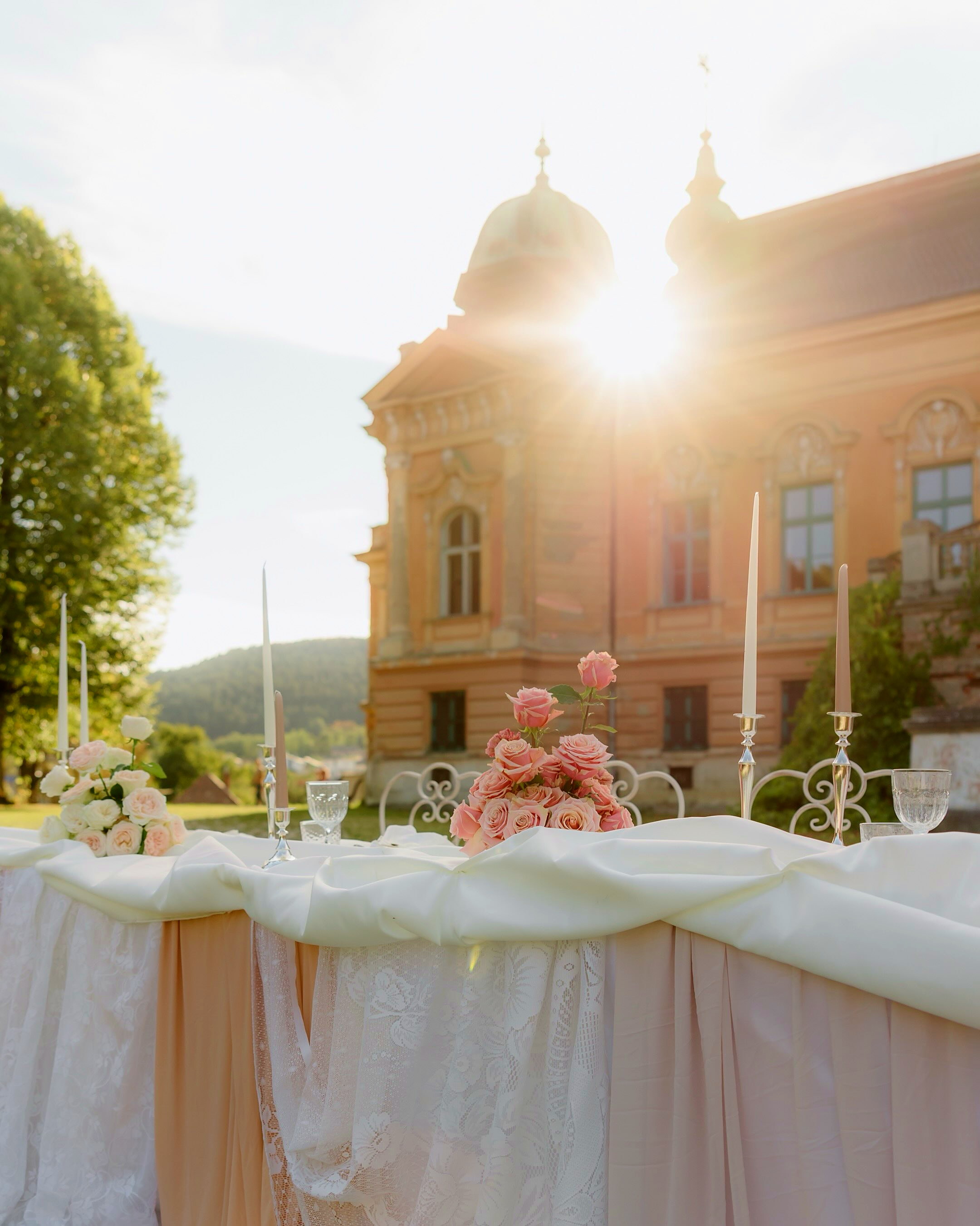 Svadobný stôl s ružovými ružami a sviečkami na zámku — realizácia @vaska.sk